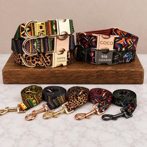Può includere: Una collezione di cinque collari e guinzagli per animali domestici con motivi vari, tra cui disegni geometrici, leopardati e a farfalla. I collari presentano fibbie in metallo, alcune incise con nomi come sunny, coco e sia e numeri di telefono.