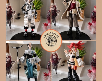 May include: A collection of four anime-style character figurines displayed on black circular bases. The figures feature diverse outfits, including tactical gear, long coats, and flowing garments, with one character holding a staff. A circular logo reads FRIK1SHOPSC.