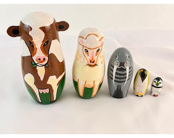 Muñecas rusas de madera pintadas a mano con forma de animales: vaca, oveja, morsa y pingüino.