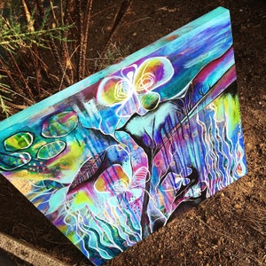 May include: Abstract painting on canvas with vibrant colors, including blue, purple, green, and yellow. The painting features a large, white flower with a swirling design and a black, organic shape in the background.