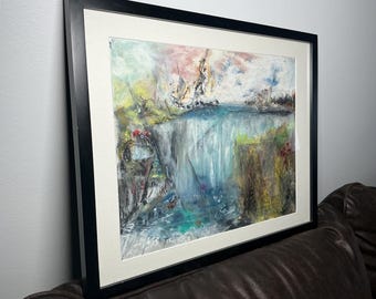 May include: Abstract landscape painting in a black frame. The artwork features a waterfall with blue, green, and white hues. The sky has pink and white colors. The painting is framed with a white mat.