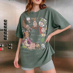 Cartoon characters from Toy Story in a retro style with names, on a green t-shirt.