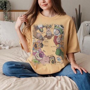 Colorful vintage-style Toy Story characters with names in playful design on a t-shirt.