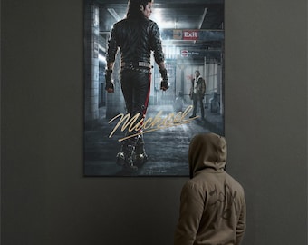 Puede incluir: Un póster enmarcado que presenta a un hombre con chaqueta y pantalón de cuero negro, con el nombre "Michael" en escritura dorada. El fondo muestra una escena de metro con un letrero de "Salida". Una persona con sudadera con capucha está mirando el póster.