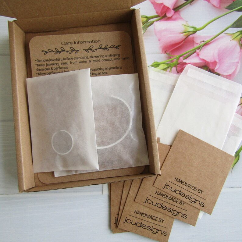 Examples of how my jewellery is packaged. Item shown in white glassine paper bag with care instructions included. Sent out in a slimline kraft parcel box.