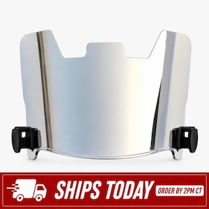 May include: A reflective silver football helmet visor with a curved, smooth surface and a central cutout at the top edge. The visor features two black plastic mounting clips attached to the lower left and right sides for secure helmet attachment.