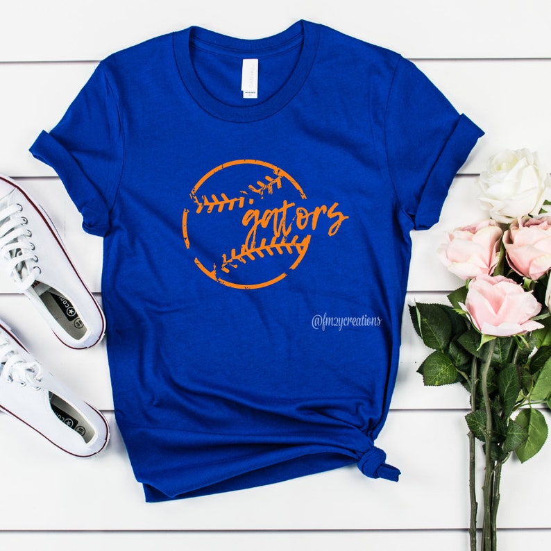Peut inclure: Un t-shirt bleu royal avec un graphique de baseball orange et le texte "gators" dans une police d'&eacute;criture us&eacute;e. Le t-shirt est fait d'un mat&eacute;riau doux et confortable et est parfait pour montrer votre esprit d'&eacute;quipe.