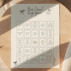 Puede incluir: Una tarjeta de juego de bingo Bar Crawl de color crema con una cuadrícula de cinco por cinco casillas de actividades, texto negro e ilustraciones pequeñas de un lazo, cerezas y una copa de champán en papel.