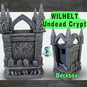 May include: Two grey, gothic-style deck boxes. One box features a relief of a figure with a crowd, tombstones, and reaching hands. The other box has a similar design. Text on the boxes reads "WILHELT Undead Crypt" and "Deckbox".