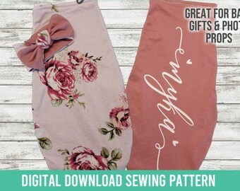 May include: A light pink baby swaddle sack with a floral rose pattern and a matching bow headband, alongside a solid dusty rose swaddle sack featuring the white cursive name Emyka and two small hearts. Text reads GREAT FOR BABY GIFTS & PHOTO PROPS.