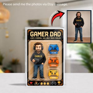 May include: A custom action figure in packaging labeled GAMER DAD LIKE A NORMAL DAD ONLY MUCH COOLER. The figure wears a black hoodie with CHARLIE printed on it and headphones. Three game controllers labeled OLIVIA, SOPHIA, and EMMA are included.