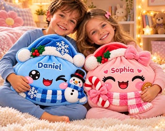 Puede incluir: Dos bolsas de peluche con cordón y caras bordadas. La bolsa azul tiene un muñeco de nieve, un copo de nieve y el nombre Daniel. La bolsa rosa tiene un bastón de caramelo, un lazo y el nombre Sophia. Ambas bolsas tienen adornos festivos.