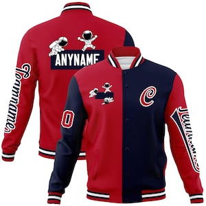 Könnte beinhalten: Rote und marineblaue Collegejacke mit weißen Akzenten. Die Jacke zeigt Astronauten-Grafiken, das Wort "ANYNAME", die Zahl "0" und den Buchstaben "C". Der Ärmel hat das Wort "Teamname" in einem geschwungenen Design.