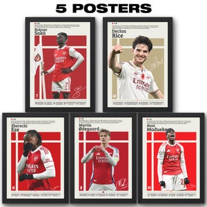 May include: Five framed posters featuring Arsenal football players. Each poster has a red and white color scheme with a player's image, name, and signature. The posters include Bukayo Saka, Declan Rice, Eberechi Eze, Martin Ødegaard, and Noni Madueke.