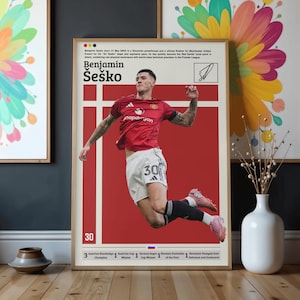 Puede incluir: Un póster enmarcado con Benjamin Šeško con camiseta roja y pantalón corto blanco, en el aire. El póster tiene un fondo rojo con líneas verticales blancas y texto, incluyendo "Benjamin Šeško" y el número "30".