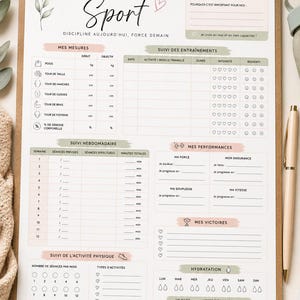 May include: A fitness tracking clipboard with a white paper sheet featuring sections for goals, body measurements, workout logs, weekly progress, performance, hydration, and notes. The design includes soft green and pink accents with botanical illustrations.