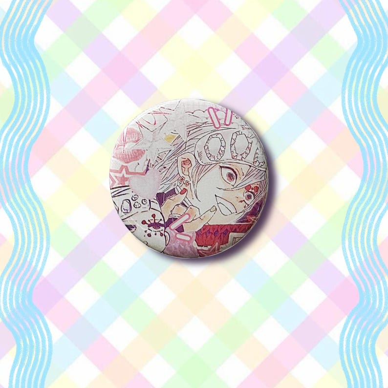 Puede incluir: Un bot&oacute;n redondo blanco con una ilustraci&oacute;n de estilo manga de un personaje con acentos rosas y rojos. El dise&ntilde;o incluye una estrella, corazones y texto japon&eacute;s. El fondo es un patr&oacute;n de cuadros pastel.
