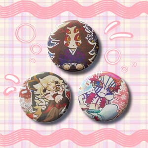 May include: Three round pinback buttons with anime-style character illustrations. The buttons feature colorful designs with characters in various poses and outfits. The background is a pink and white plaid pattern.