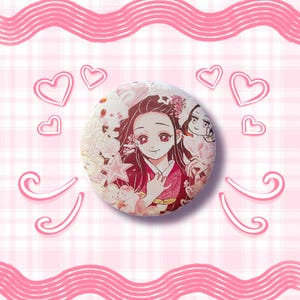 May include: A round button featuring a colorful anime character with long black hair and red eyes, wearing a pink kimono. The button is surrounded by pink hearts and swirls on a pink and white checkered background.