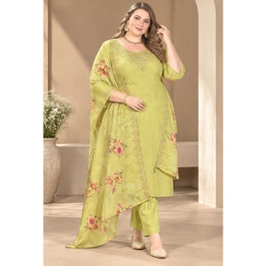 May include: A lime green three-piece outfit consisting of a long-sleeved tunic with a round neckline, matching straight-leg trousers, and a sheer, lightweight shawl draped over the shoulders, all featuring a delicate floral print in pink and orange.