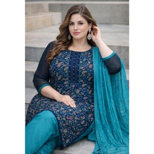 May include: A navy blue and teal salwar kameez set. The top features a paisley pattern with a navy blue yoke and sleeves. The outfit includes matching teal pants and a teal dupatta. The sleeves are sheer, and the dupatta has a sequined trim.