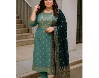 May include: Teal-colored salwar kameez set with gold geometric and floral patterns. The outfit includes a long tunic, matching pants, and a dark teal shawl with gold embroidery. The woman is wearing gold jewelry and heels.