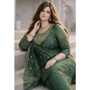 May include: A dark green long-sleeved tunic dress featuring intricate gold embroidery around the neckline and scattered floral motifs throughout the fabric. The garment includes a matching draped shawl with a decorative gold embroidered border.
