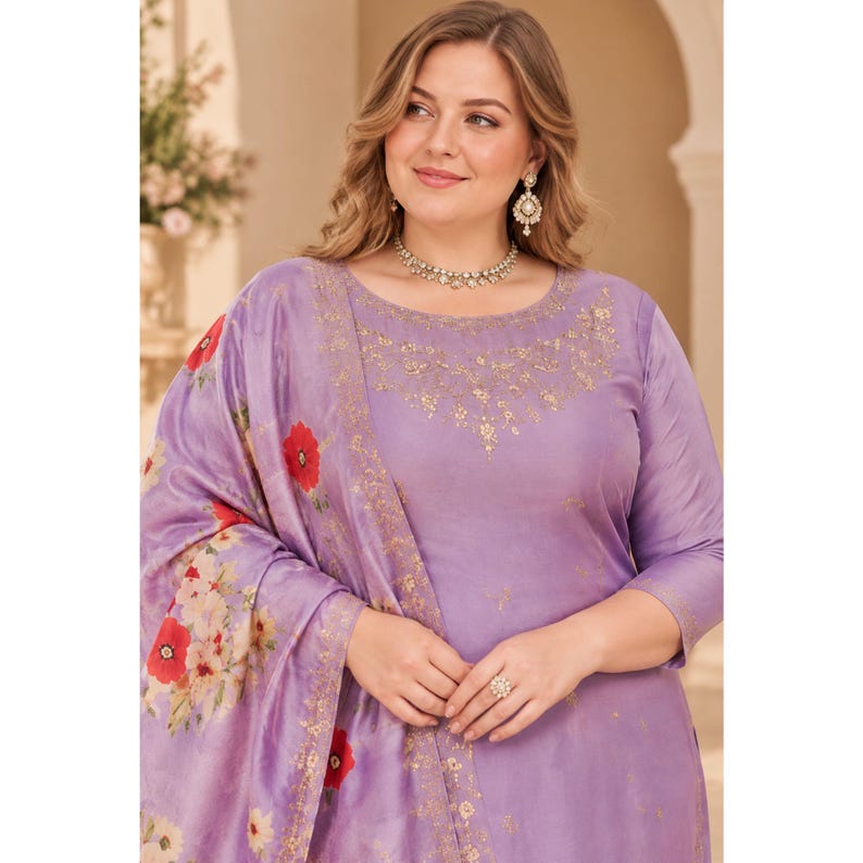 May include: A lavender-colored kurta set featuring a round neckline with intricate gold embroidery. The fabric displays a subtle sheen and is paired with a matching dupatta adorned with a vibrant floral print of red poppies and white blossoms.