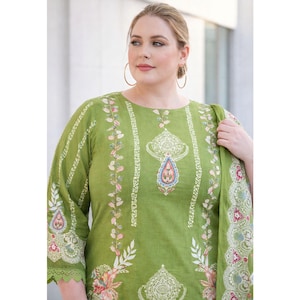 May include: A woman wearing a green tunic with floral and paisley patterns. The tunic has a round neckline and three-quarter sleeves. The design includes vertical stripes and a central paisley motif, with colorful accents.