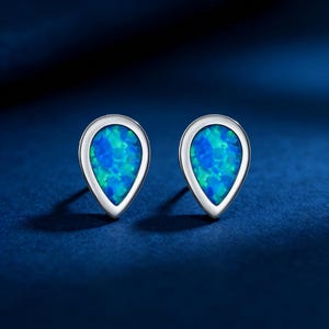 May include: A white ceramic mug with a black handle and the text "But First, Coffee" in a black, handwritten-style font. The mug is on a white surface.