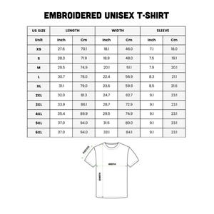 Puede incluir: Una tabla blanca con texto negro que detalla las medidas de una camiseta unisex bordada. La tabla incluye tallas estadounidenses, medidas de largo, ancho y manga en pulgadas y cent&iacute;metros.