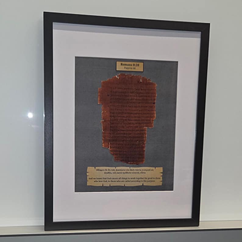 Puede incluir: Obra de arte enmarcada con un fragmento de texto antiguo. El texto es de color marr&oacute;n rojizo, montado sobre un fondo gris y enmarcado en negro. Se ven dos peque&ntilde;as placas con texto.