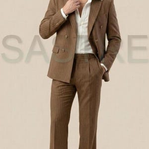 May include: A white ceramic mug with a black handle and the text "But First, Coffee" in a bold, black font. The mug is set against a blurred background, suggesting a cozy setting.