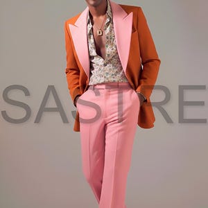 May include: A stylish ensemble featuring an orange blazer with a pink lapel, paired with pink trousers and a floral print shirt. The outfit is completed with brown shoes. The word "SASTRE" is visible in the background.