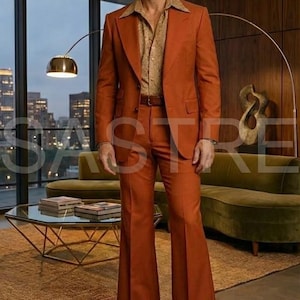 May include: A rust-colored suit with a wide lapel jacket and flared pants. The suit is paired with a patterned button-down shirt and a brown belt. The outfit is completed with brown leather shoes. The setting is a retro-style living room.