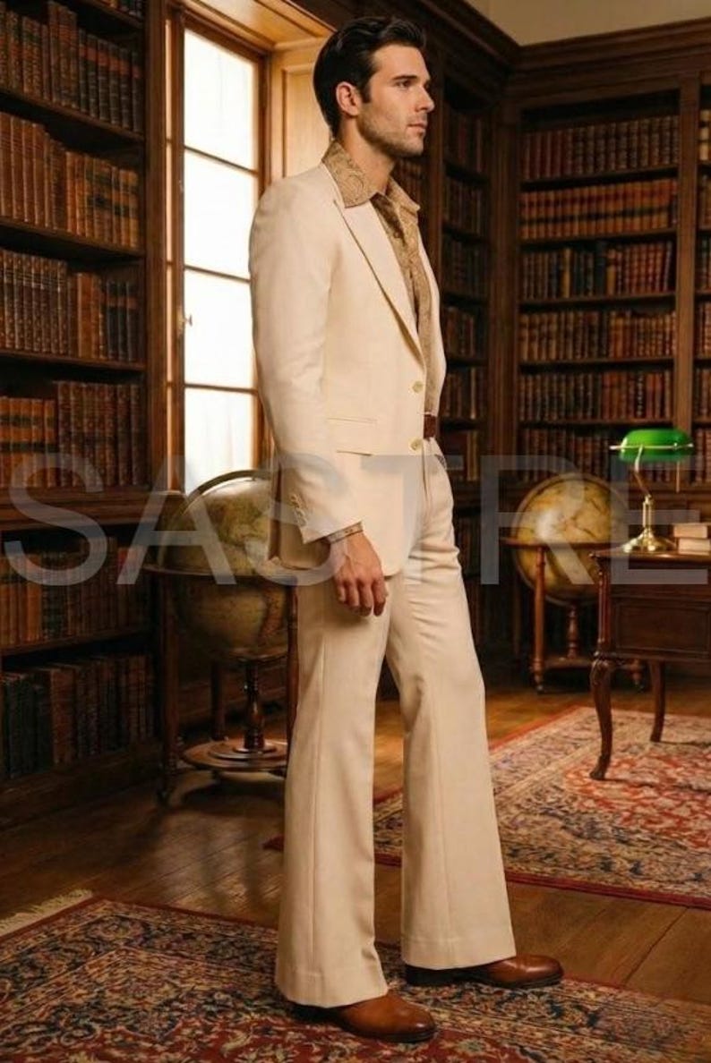 May include: A cream-colored suit with a flared leg, paired with a patterned shirt. The suit is worn with brown leather shoes. The background features a library with bookshelves and globes, creating a vintage aesthetic.
