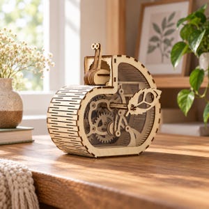 Puede incluir: Un modelo mecánico de madera clara con forma de caracol y un mecanismo interno de engranajes. La concha presenta un diseño de hoja recortada en el lateral y el caracol tiene dos antenas erguidas. Estructura hecha de madera cortada con láser.