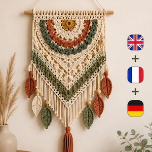 May include: A cream-colored macrame wall hanging suspended from a wooden dowel, featuring concentric semicircular patterns in mustard yellow, rust orange, and forest green. The piece includes dangling crocheted leaf accents and a central tassel.