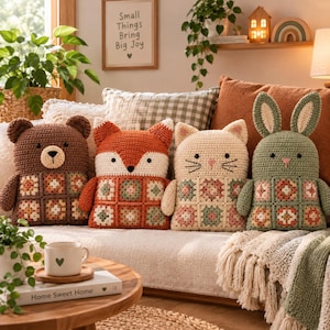 May include: Four handmade crochet animal cushions shaped like a bear, a fox, a cat, and a rabbit. Each cushion features a brown, orange, cream, or sage green body with a square granny square pattern on the front and embroidered facial features.