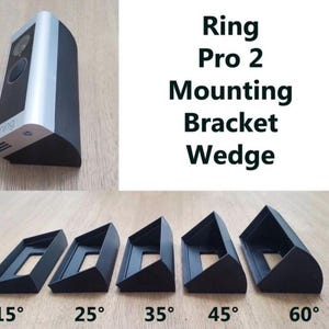 Puede incluir: Un timbre de video Ring Pro 2 plateado y negro con una cuña de soporte de montaje. La imagen también muestra cinco soportes de cuña negros con ángulos de 15°, 25°, 35°, 45° y 60°.