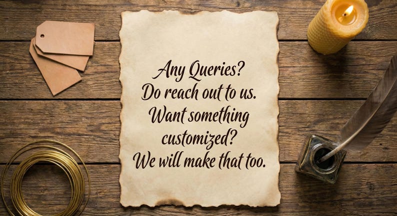 May include: A rustic wooden surface with a parchment scroll featuring the text "Any Queries? Do reach out to us. Want something customized? We will make that too." Also, a lit candle, inkwell, feather, tags, and wire.