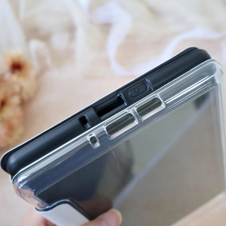 Peut inclure: Une coque de protection pour tablette avec un panneau arri&egrave;re transparent et un cadre noir solide. Le bord sup&eacute;rieur pr&eacute;sente des d&eacute;coupes pr&eacute;cises pour le bouton d'alimentation, les haut-parleurs et les ports, r&eacute;v&eacute;lant le design fonctionnel.