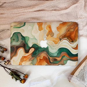 Può includere: Custodia per laptop con design astratto nei toni del verde, arancione, marrone e crema. Presenta un motivo di linee fluide e il logo Apple. Progettata per laptop, offre protezione e stile.