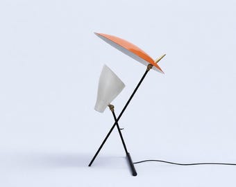 Lámpara de mesa moderna de mediados de siglo con pantalla de metal naranja y luz de escritorio ajustable.