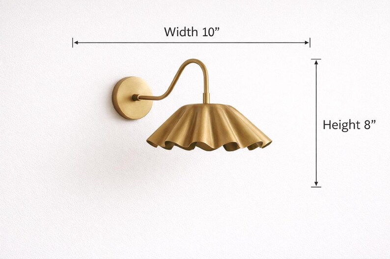 Pair of vintage brass wall sconces with downward, ruffled shades and curved arms, antique brass finish.