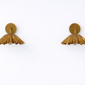 Pair of vintage brass wall sconces with downward, ruffled shades and curved arms, antique brass finish.