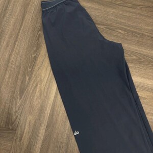 Puede incluir: Pantalones deportivos azul marino oscuro con un logotipo blanco en la pierna. Los pantalones tienen una cintura con cord&oacute;n y ribete blanco. Los pantalones est&aacute;n hechos de un material ligero.