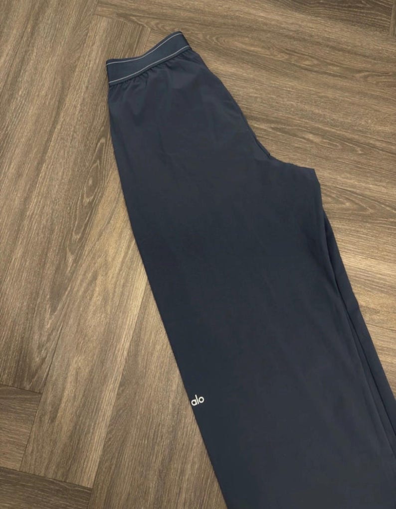 Puede incluir: Pantalones deportivos azul marino oscuro con un logotipo blanco en la pierna. Los pantalones tienen una cintura con cord&oacute;n y ribete blanco. Los pantalones est&aacute;n hechos de un material ligero.