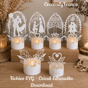 Peut inclure: Six découpages en papier blanc présentant des motifs complexes de couples, d'un arbre et de fleurs, montés sur une base cylindrique avec une lumière interne. Le texte "Creamily france" et "Fichier SVG - Cricut Silhouette Download" est visible.