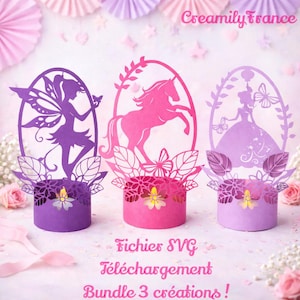 Peut inclure: Trois découpes de papier en violet, rose et lavande, chacune avec un design différent : une fée, une licorne et une princesse. Les découpes sont posées sur des bases cylindriques avec des détails floraux et de feuilles. Le texte "Creamily France" est visible.